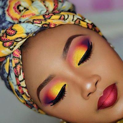 A person with colorful makeup and turban

Description automatically generated