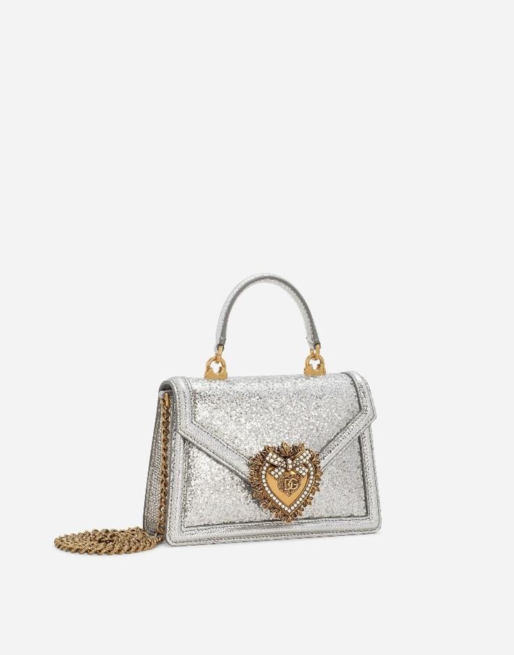 A silver purse with a gold heart on it

Description automatically generated