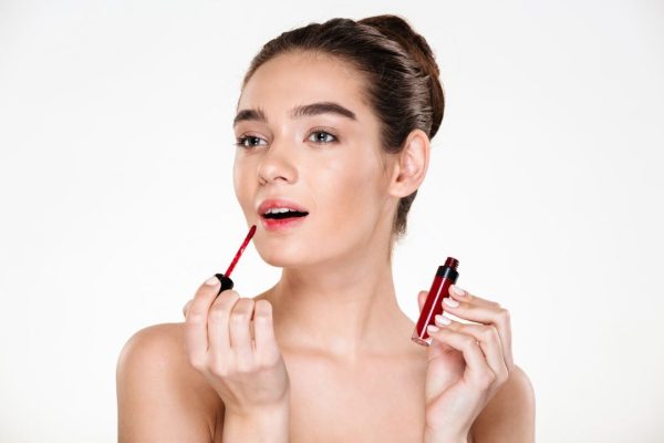 beauty-portrait-elegant-half-naked-lady-with-hair-bun-applying-red-lipgloss-looking-aside_171337-560
