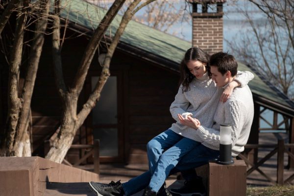 full-shot-romantic-couple-sitting-outdoors_23-2149411862