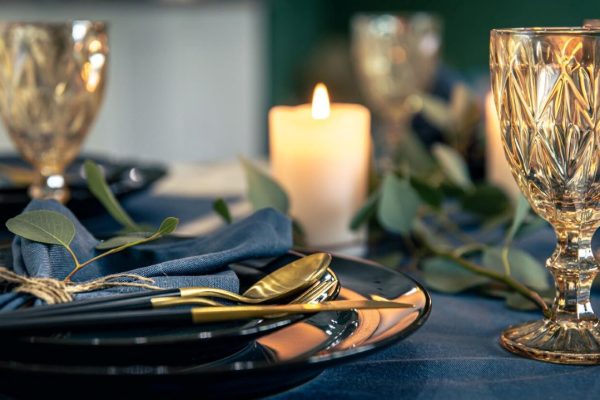 table-setting-with-textured-wine-glasses-candles-leaves_169016-18721